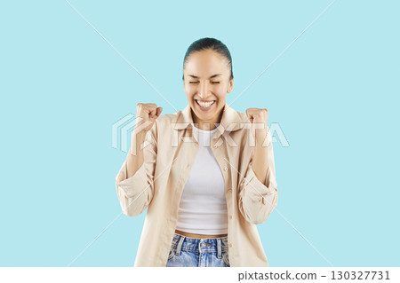 Portrait Of Happy Woman Celebrating Success On Blue Background 130327731
