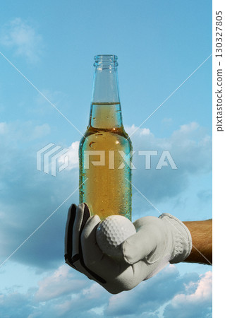 Hand in golf glove holding beer bottle and golf ball against blue sky refreshing mood Hand in golf glove holding beer bottle and golf ball against blue sky refreshing mood 130327805