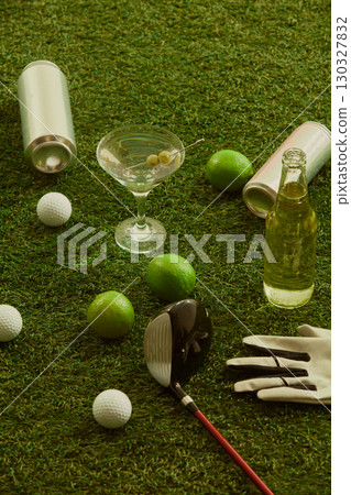 Golf equipment martini glass beer bottles limes and golf balls arranged on grass festive mood Golf equipment martini glass beer bottles limes and golf balls arranged on grass festive mood 130327832