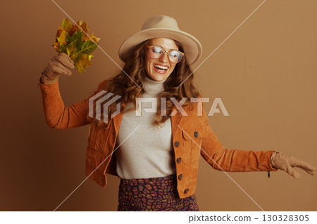 Happy Woman Celebrating Autumn with Leaves 130328305