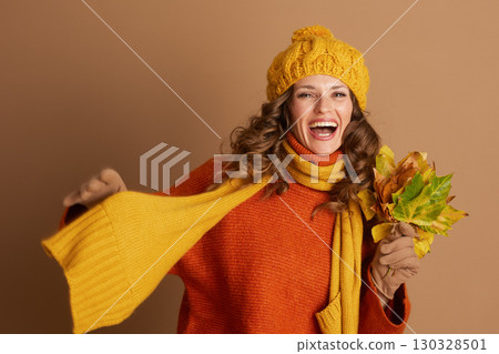 Cheerful Woman in Turtleneck Laughing with Fall Leaves Cheerful Woman in Turtleneck Laughing with Fall Leaves 130328501