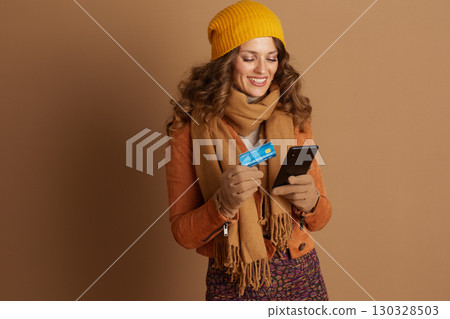 Woman Smiling while Shopping Online with Phone Woman Smiling while Shopping Online with Phone 130328503