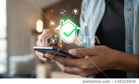 Smartphone with home security app showing digital shield and checkmark icons for protection and safety Smartphone with home security app showing digital shield and checkmark icons for protection and safety 130328926