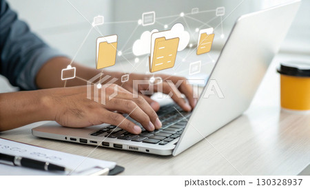 Hands typing on laptop keyboard with digital folder icons floating above, symbolizing cloud storage and data management 130328937