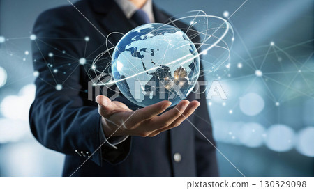 businessman in dark suit holding holographic globe with digital network 130329098