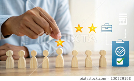 Wooden candidate selection with hand placing star rating on figure showing hiring and evaluation satisfaction 130329198