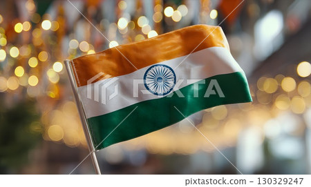 Indian flag waving with saffron, white, and green colors. The Ashoka Chakra is visible in the center. Background features festive decorations. 130329247