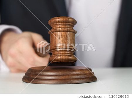 Auctioneer is hitting with gavel 130329613