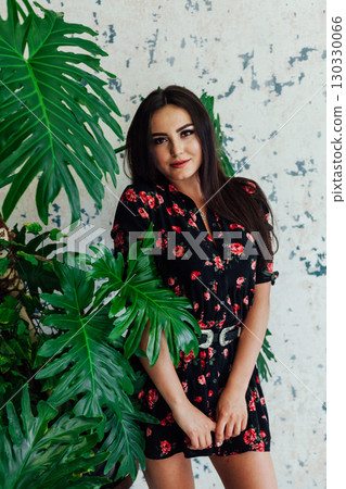 Portrait of a beautiful woman in a black flower dress with a smile 130330066