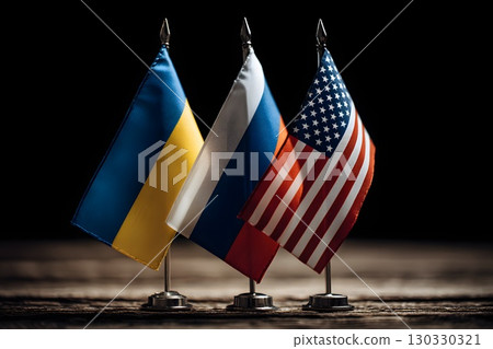 Three flags representing Ukraine, Russia, and the USA stand on a wooden table. The scene symbolizes negotiations and peace treaty discussions among the leaders. 130330321