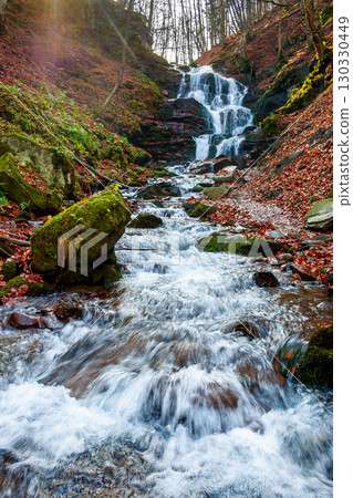 beautiful autumn scenery near the waterfall shypot. popular travel destination of Ukrainian Carpathians. mossy rocks near water stream. steep slopes in fallen foliage. sunny afternoon in autumn beautiful autumn scenery near the waterfall shypot. popular travel destination of Ukrainian Carpathians. mossy rocks near water stream. steep slopes in fallen foliage. sunny afternoon in autumn 130330449