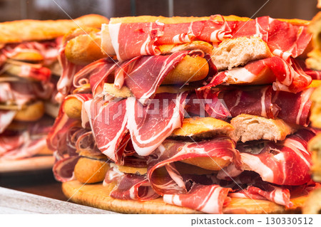 Spanish bocadillos with Iberian ham, laid out in a slide on the display case 130330512