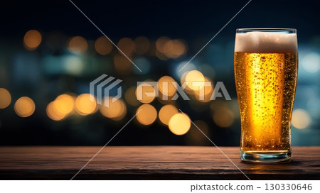 A glass of golden beer sits on a wooden table. The background features blurred lights, creating a festive atmosphere typical of Oktoberfest in Bavaria, Germany. A glass of golden beer sits on a wooden table. The background features blurred lights, creating a festive atmosphere typical of Oktoberfest in Bavaria, Germany. 130330646