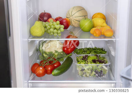 Open refrigerator full of fresh fruits and vegetables promoting healthy eating habits 130330825