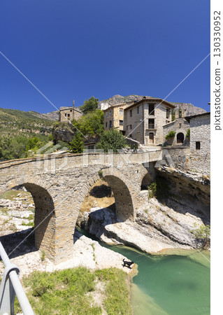 Medieval bridge crossing turquoise river in Roda de Isabena, Huesca, Spain 130330952