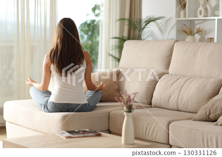 Woman doing yoga at home looking through a window 130331126