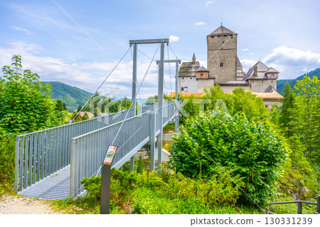 Mauterndorf Castle stands prominently in Austria, surrounded by lush greenery and scenic mountains. Visitors can access it via a modern bridge leading to its historic grounds. Mauterndorf Castle stands prominently in Austria, surrounded by lush greenery and scenic mountains. Visitors can access it via a modern bridge leading to its historic grounds. 130331239