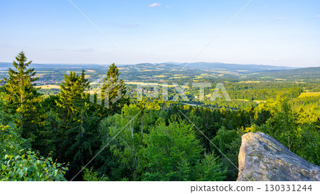 At dusk, the Popov Cliffs in the Lusatian Mountains offer a breathtaking view. Surrounding forested hills and valleys create a tranquil atmosphere perfect for evening exploration. 130331244