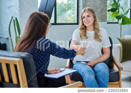 Smiling happy young woman at session with psychologist, therapist Smiling happy young woman at session with psychologist, therapist 130331983