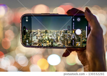 The moment when a smartphone captures the illuminated city night view The moment when a smartphone captures the illuminated city night view 130332281