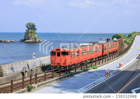 冰見線 Kiha 40 系列本地列車在 Amaharashi 海岸的 Onnaiwa 岩旁運行 130332998