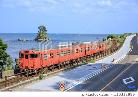 冰見線 Kiha 40 系列本地列車在 Amaharashi 海岸的 Onnaiwa 岩旁運行 130332999