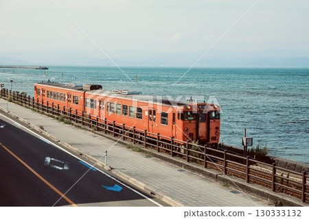 Himi Line Kiha 40 series local train running along the Amaharashi Coast with the Noto Peninsula in the background 130333132