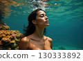 Woman swims underwater in coral sea or ocean 130333892
