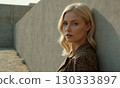 Woman model with long hair stands on concrete wall background 130333897