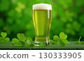 Glass of green foamy irish beer stands on green grassy clover background. St. Patrick Day 130333905