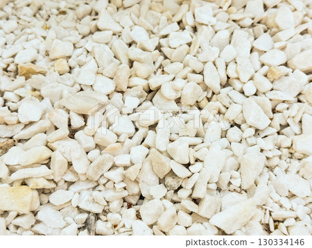 White gravel stones in close-up view. Natural texture, construction material and decorative surface for landscape design. White gravel stones in close-up view. Natural texture, construction material and decorative surface for landscape design. 130334146