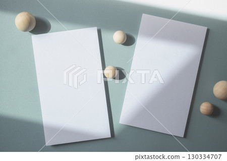 Empty white blank greeting or invitation card with wooden ball on blue background. Mock up presentation. Empty white blank greeting or invitation card with wooden ball on blue background. Mock up presentation. 130334707