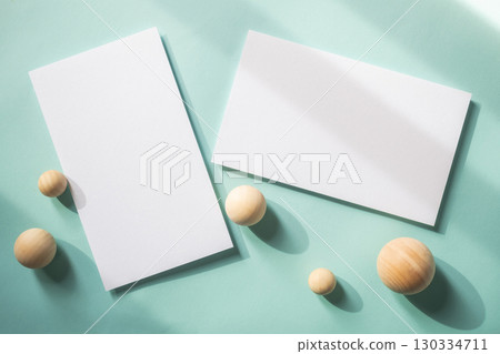 Empty white blank greeting or invitation card with wooden ball on blue background. Mock up presentation. 130334711