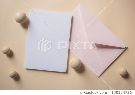 Empty white blank greeting or invitation card with pink envelope on beige background. Mock up presentation. Empty white blank greeting or invitation card with pink envelope on beige background. Mock up presentation. 130334726