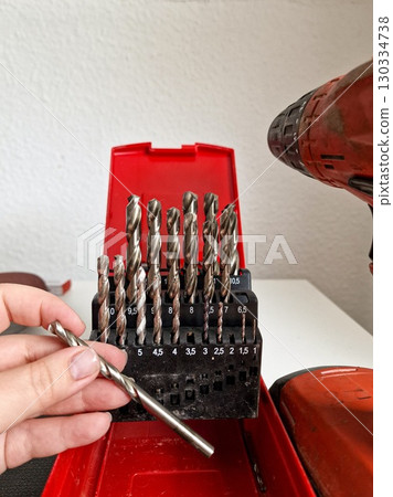 Hand Holding Drill Bit with Box of Assorted Drill Bits 130334738