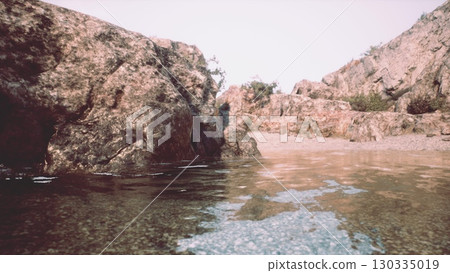 A tranquil body of water embraced by magnificent rocky cliffs in Portugal. A tranquil body of water embraced by magnificent rocky cliffs in Portugal. 130335019