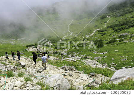 夏天蔚藍天空下，登山者攀登千疊敷冰鬥的岩石坡道 130335083