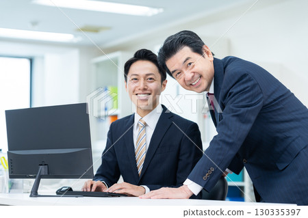 在辦公室工作的中年商人 在辦公室工作的中年商人 130335397