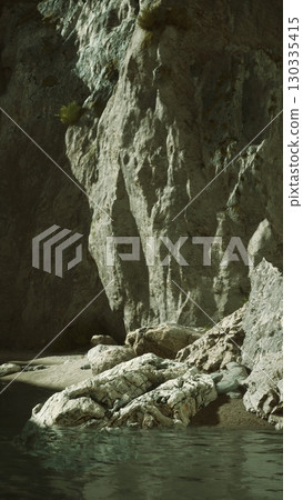 A serene view of a jagged cliff beside still water under the soft light of early evening. 130335415