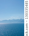 Clear blue ocean with mountains in the background 130335485