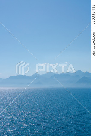 Clear blue ocean with mountains in the background 130335485