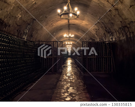 Dimly lit wine cellar with rows of bottles and warm lighting at dusk Dimly lit wine cellar with rows of bottles and warm lighting at dusk 130335815