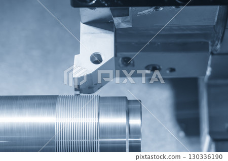 Close up scene the CNC lathe machine thread cutting the metal shaft parts in the blue tone scene. Close up scene the CNC lathe machine thread cutting the metal shaft parts in the blue tone scene. 130336190