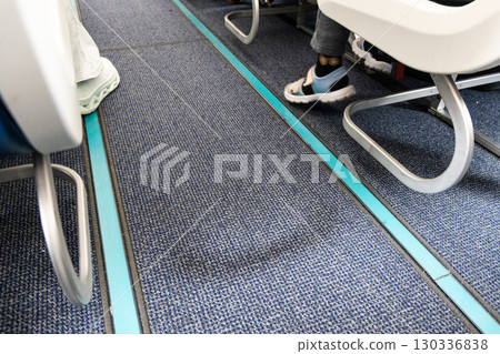 Close-up on airplane cabin carpeted floor with reflective and illuminated guide lines for evacuation during emergency Close-up on airplane cabin carpeted floor with reflective and illuminated guide lines for evacuation during emergency 130336838