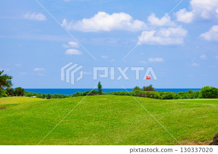 A resort golf course and green flag against the refreshing blue tropical sky and sea (Miyakojima City, Okinawa Prefecture) 130337020