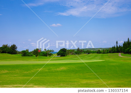 A resort golf course and green flag against the refreshing blue tropical sky and sea (Miyakojima City, Okinawa Prefecture) 130337154