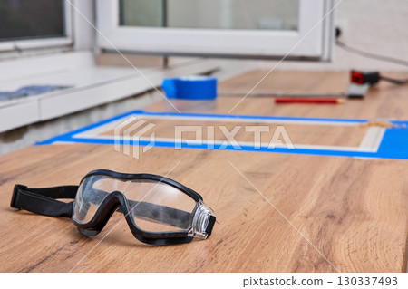 protective glasses lying on kitchen countertops, marking cutting hole for the sink, renovation, copy space 130337493