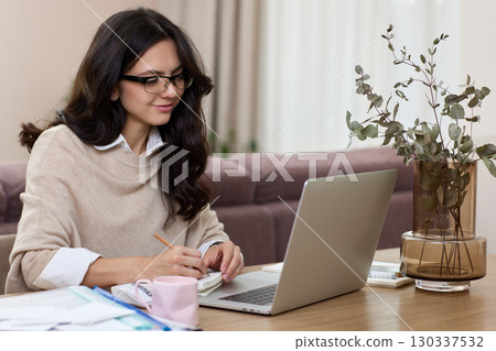 pretty woman working at home office, female worker using laptop computer for contact with clients online pretty woman working at home office, female worker using laptop computer for contact with clients online 130337532