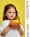 cute Caucasian little child girl holding grapefruit on yellow background 130337674