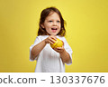 cute funny little child girl holding lemon on yellow background 130337676